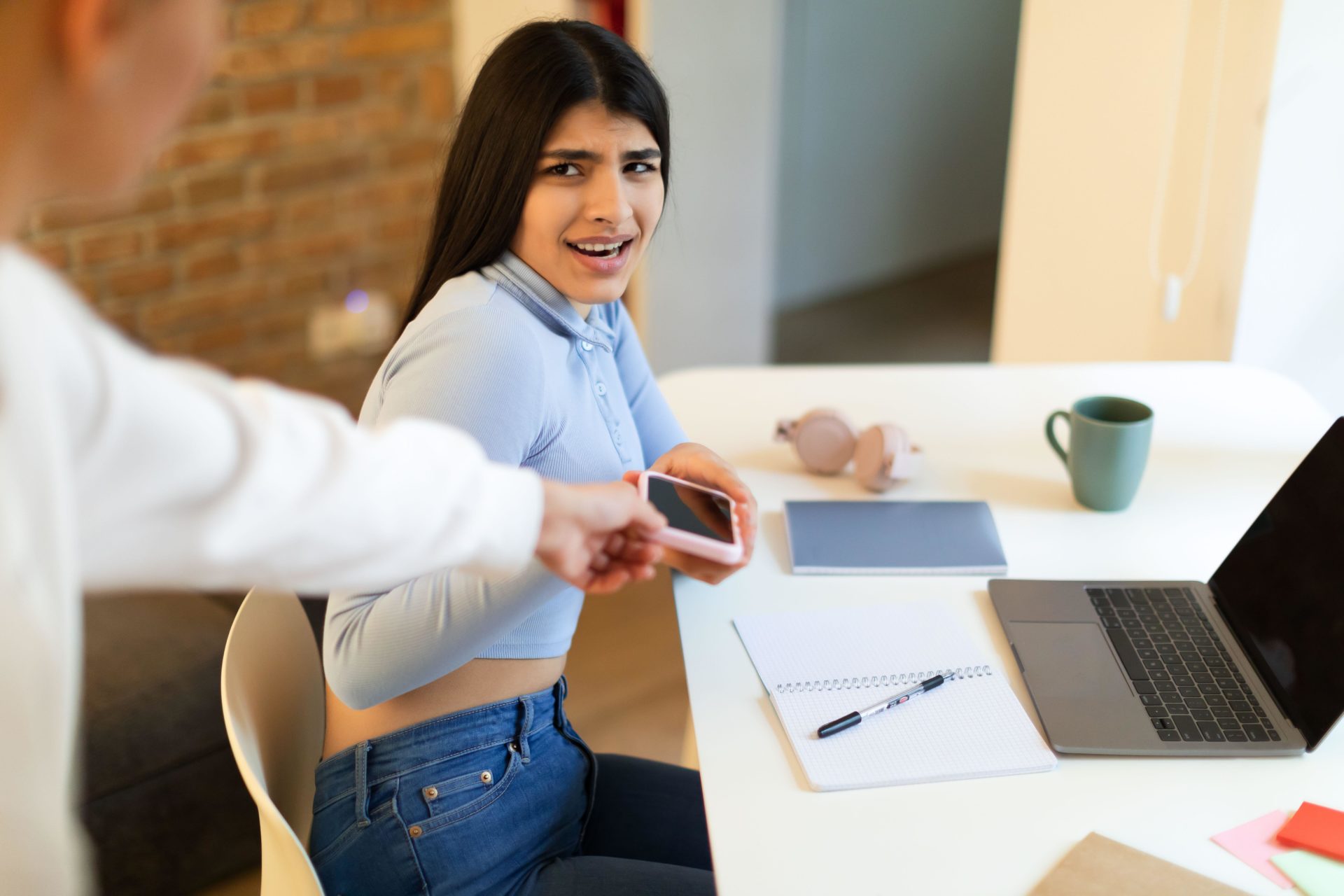Parent taking away smartphone from teenage daughter. Image: Prostock-studio / Alamy Stock Photo